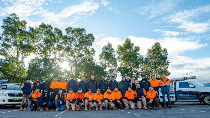 large group of tradies standing outside for a team photo