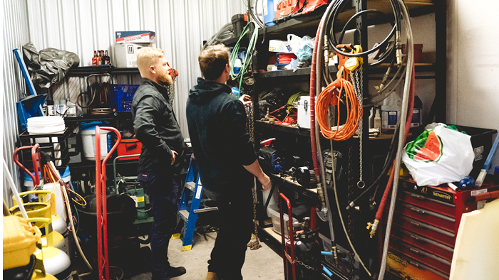 two men in stock room looking at shelves filled with building materials