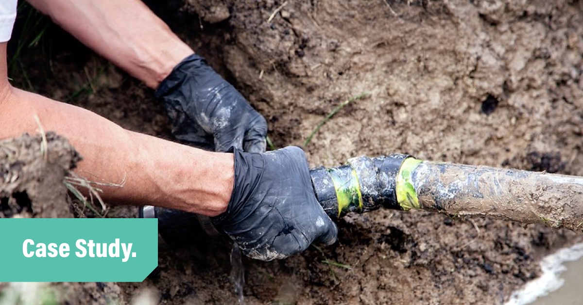 A photo of a plumbers hands wearing black gloves whole working on a muddy pipe. Overlayed are the words Case Study.