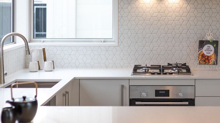 kitchen counter with geometric white titles as a backsplash