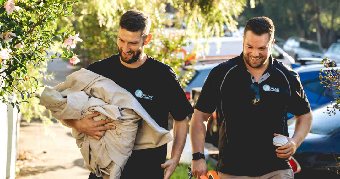 two tradies carrying sheets