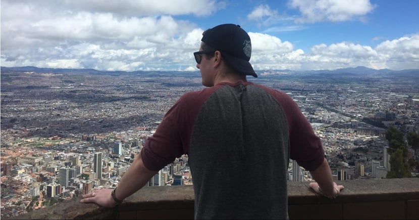 Andrew stands out on an old balcony overlooking Columbia city