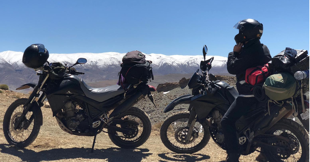 two motorbikes with snowy peak mountains in background