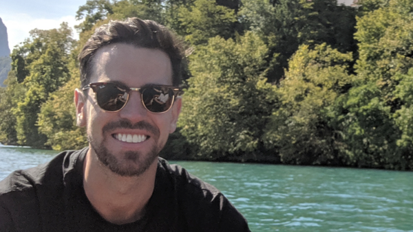 sam by a green river and trees
